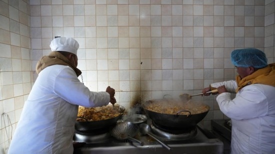 1月14日，服務(wù)隊的兩名廚師正在為村民們做午飯。新華社記者 邱星翔 攝