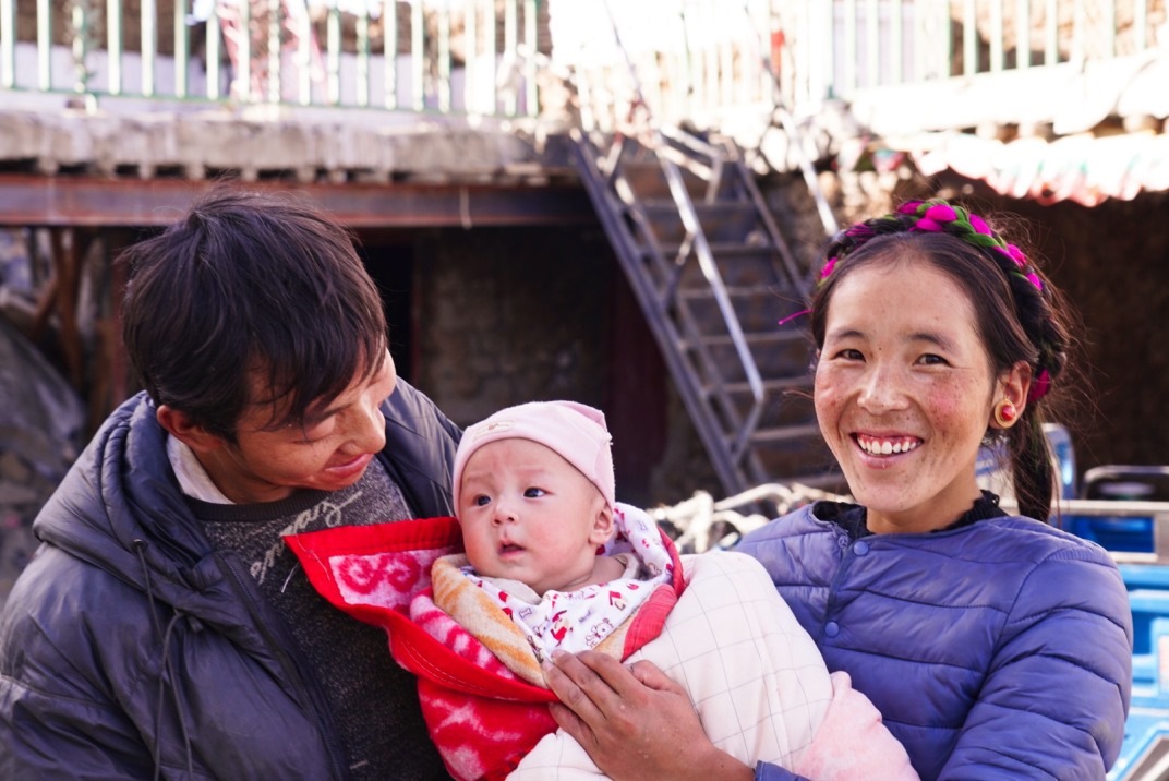 1月11日，在西藏日喀則市人民醫(yī)院，受災(zāi)群眾抱著自己在地震中受傷的孩子康復(fù)出院。人民日?qǐng)?bào)記者徐馭堯攝