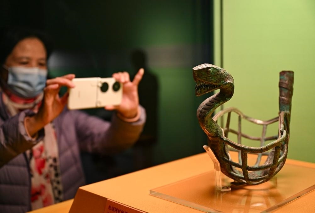1月14日，觀眾在上海博物館蛇年迎春展拍攝展品蛇綱網(wǎng)狀銅器。新華社發(fā)（陳浩明攝）