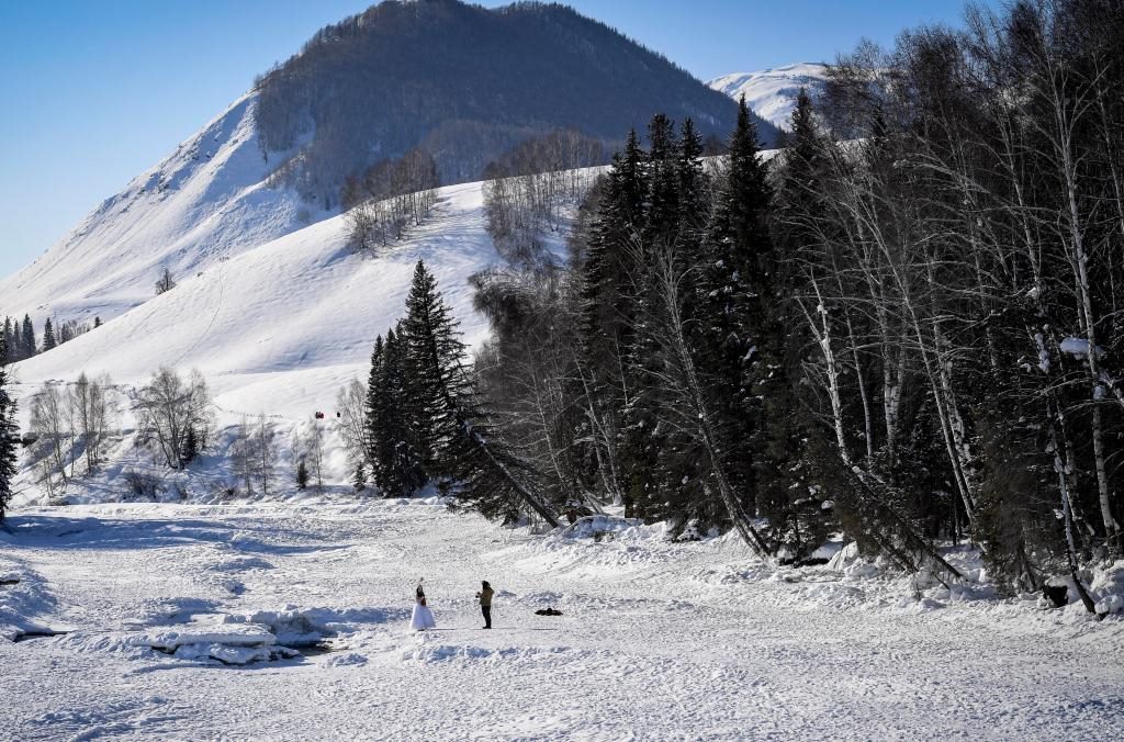 2024年2月5日，兩名游客在新疆阿勒泰地區(qū)布爾津縣禾木村拍照。新華社記者 馬鍇 攝