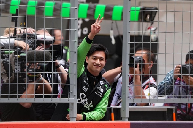 2024年4月19日，索伯車隊(duì)中國(guó)車手周冠宇（中）在練習(xí)賽前向觀眾致意。當(dāng)日，F(xiàn)1中國(guó)大獎(jiǎng)賽在上海開(kāi)賽。中國(guó)車手周冠宇主場(chǎng)首秀參賽。新華社記者 夏一方攝