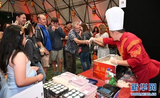圖為游客在燈節(jié)現(xiàn)場購買小吃。（圖片由奧克蘭中國文化中心提供）