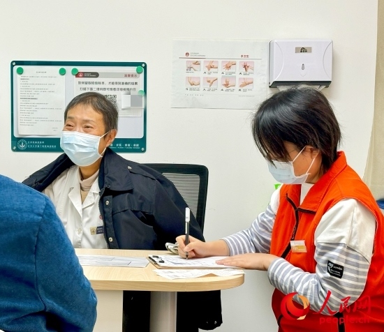 秦苑（中）接診患者。人民網(wǎng)記者 金慧慧攝