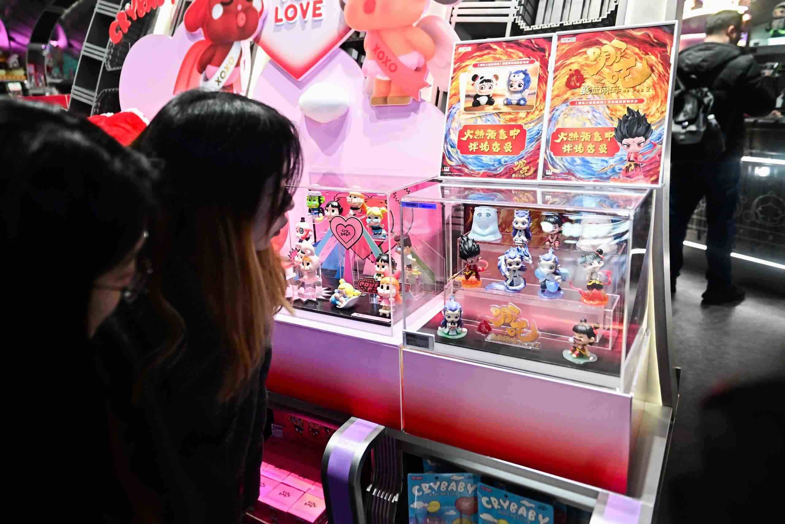 △2025年2月22日，上海，市民在圍觀《哪吒之魔童鬧?！废嚓P(guān)手辦盲盒。