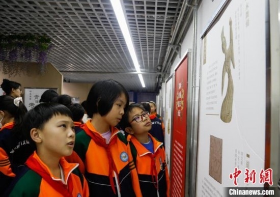 圖為學生參觀青海省博物館“1+3”主題流動展覽，了解木舞俑。中新社記者 馬銘言 攝