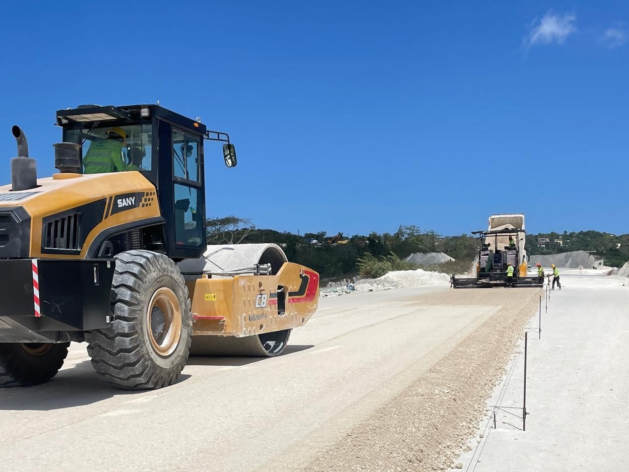 圖為中企承建的牙買(mǎi)加蒙特哥貝繞城路項(xiàng)目基層試驗(yàn)段正在進(jìn)行攤鋪和碾壓施工，相關(guān)施工工作已于日前順利完成。中國(guó)港灣美洲區(qū)域公司供圖