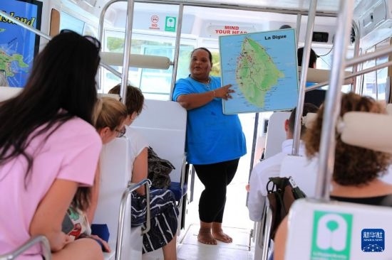 3月15日，一名導(dǎo)游在游艇上為游客介紹塞舌爾拉迪格島。新華社記者 董江輝 攝