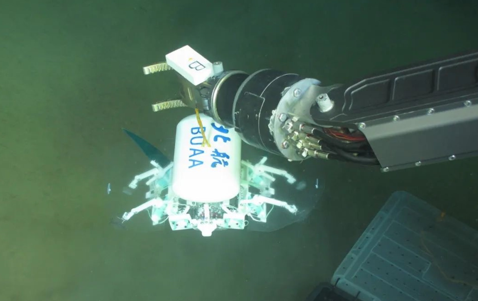 科研人員利用機(jī)械臂將北航深海小型機(jī)器人投于馬里亞納海溝。校方供圖