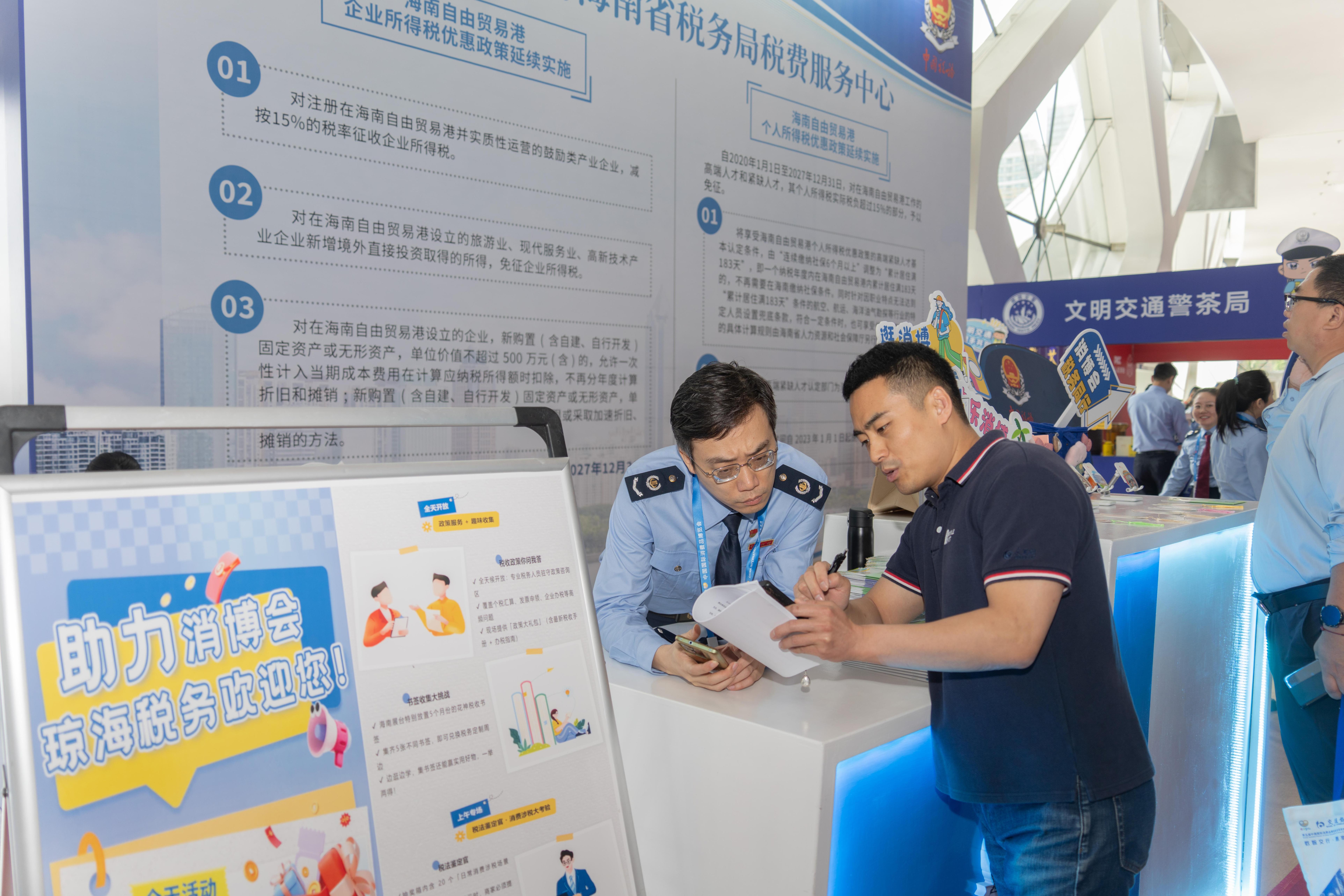 稅務(wù)服務(wù)臺(tái)工作人員向記者介紹服務(wù)參展外商的具體舉措。人民網(wǎng)記者 許崢攝