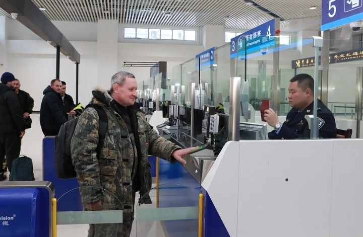 2024年12月10日，在黑河公路口岸旅檢大廳，黑河出入境邊防檢查站民警為首班次客車入境旅客辦理邊檢通關(guān)手續(xù)。當(dāng)日，中國(guó)黑河公路口岸—俄羅斯卡尼庫(kù)爾干公路口岸旅客運(yùn)輸正式開通。新華社發(fā)（劉松攝）