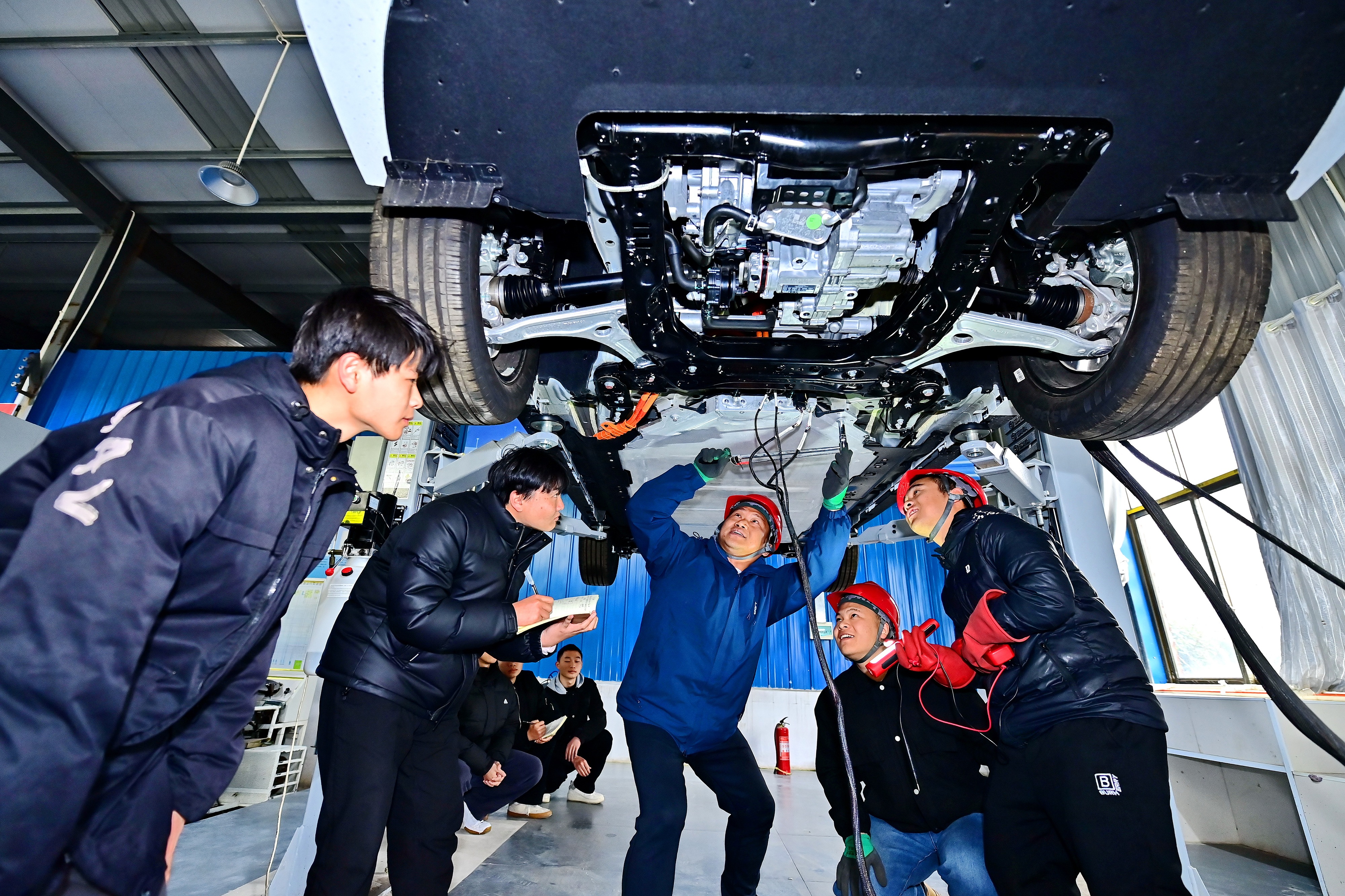 2025年2月，江西省宜春市，豐城市的一所技工學(xué)校實(shí)訓(xùn)基地內(nèi)，新能源汽車運(yùn)維專業(yè)學(xué)生在老師的指導(dǎo)下學(xué)習(xí)新能源汽車電池包檢修技術(shù)。