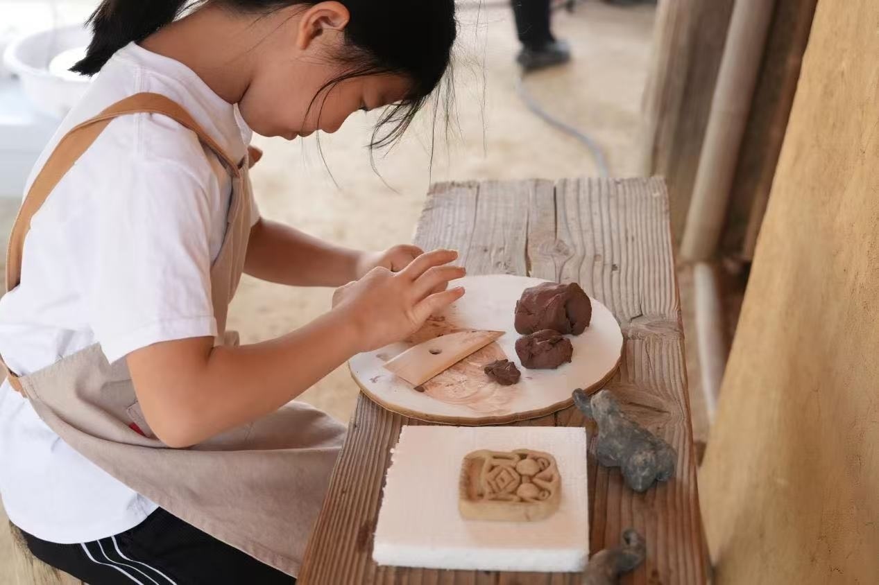 游客制作良渚特色陶藝品。良渚博物院供圖