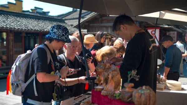 “五一”期間，游客正在烏鎮(zhèn)“水鄉(xiāng)碼頭”挑選購買文創(chuàng)產(chǎn)品。受訪者供圖