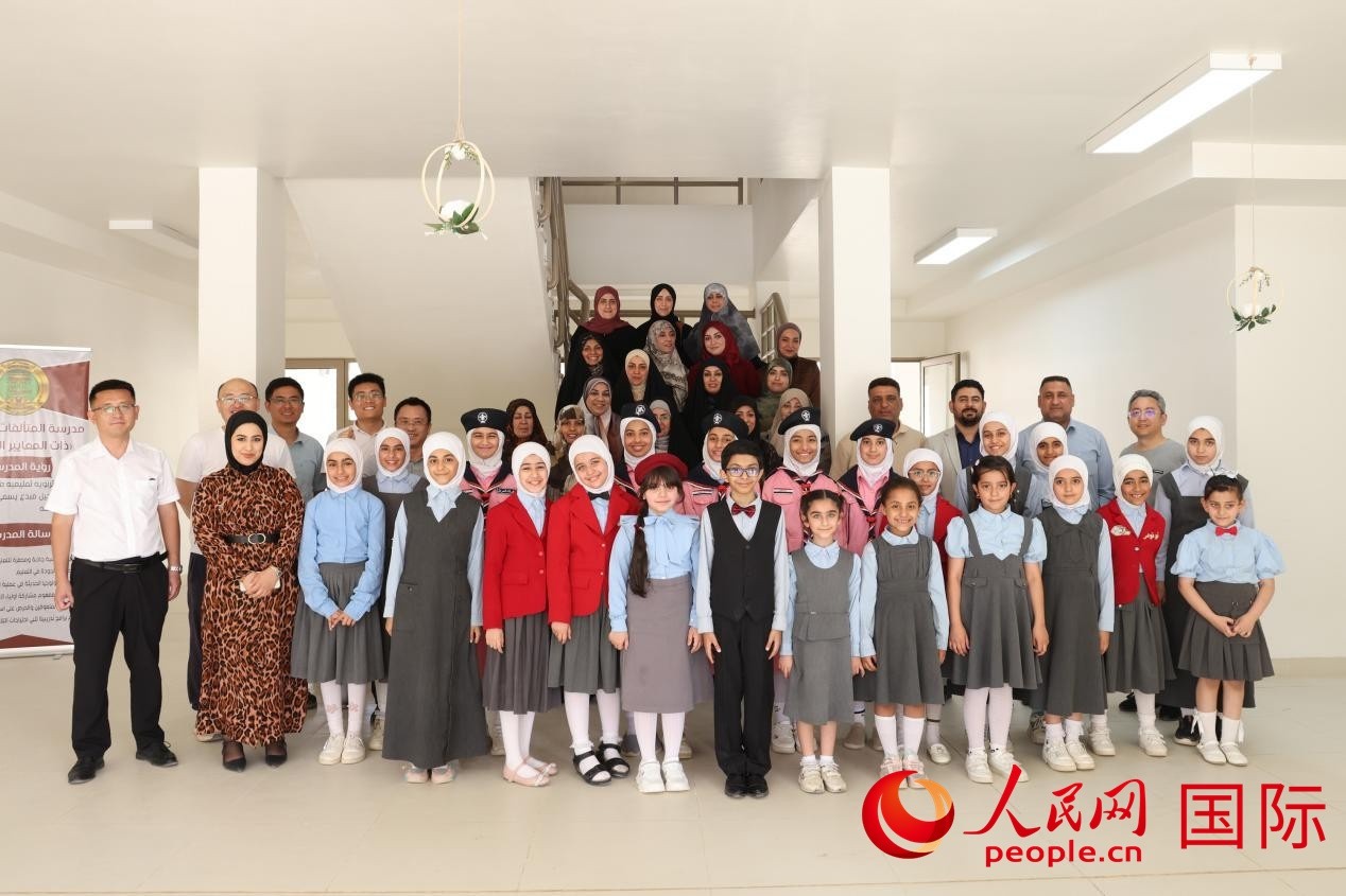 中國電建員工與阿爾穆塔?阿里卡特國際學(xué)校的師生及政府官員等合影。人民網(wǎng)記者 薛丹攝