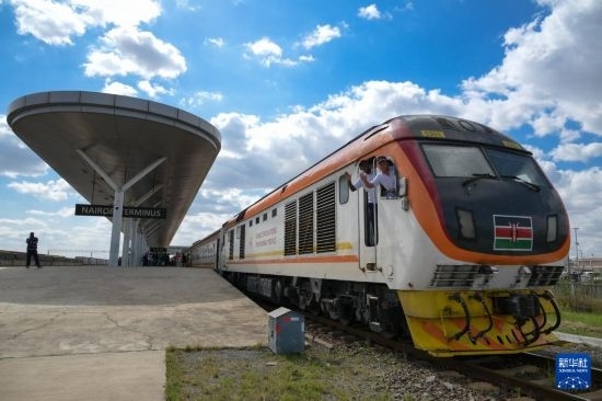 5月31日，在蒙內(nèi)鐵路內(nèi)羅畢站，機(jī)車駕駛員蔣立平（右）和博爾在即將開往蒙巴薩的E2次列車上揮手致意。新華社記者 楊光 攝