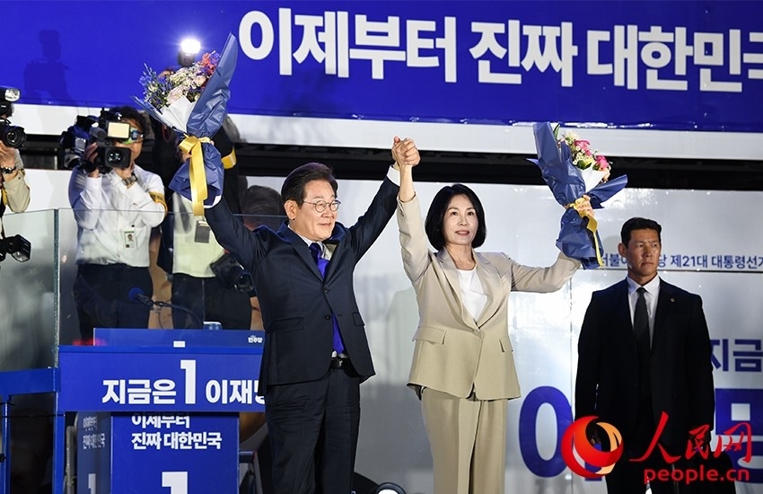 6月4日凌晨，確定當(dāng)選韓國(guó)總統(tǒng)的李在明舉手向歡呼的支持者們致意。 人民網(wǎng) 康炯彬攝