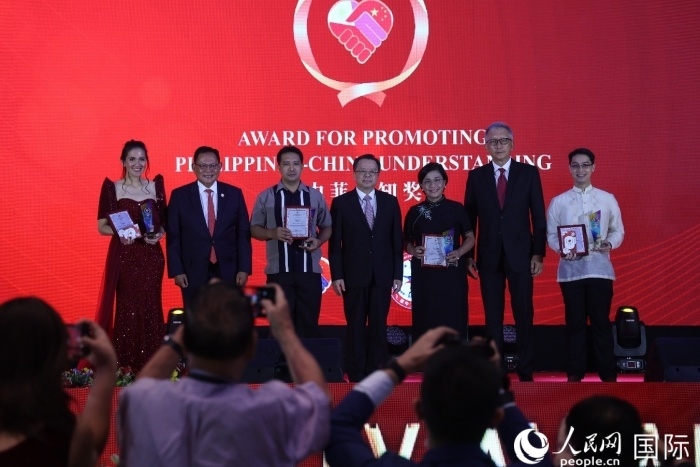 黃溪連大使和菲中了解協(xié)會主席與榮獲“友誼獎”的獲獎者合影留念。人民網記者 樊帆攝